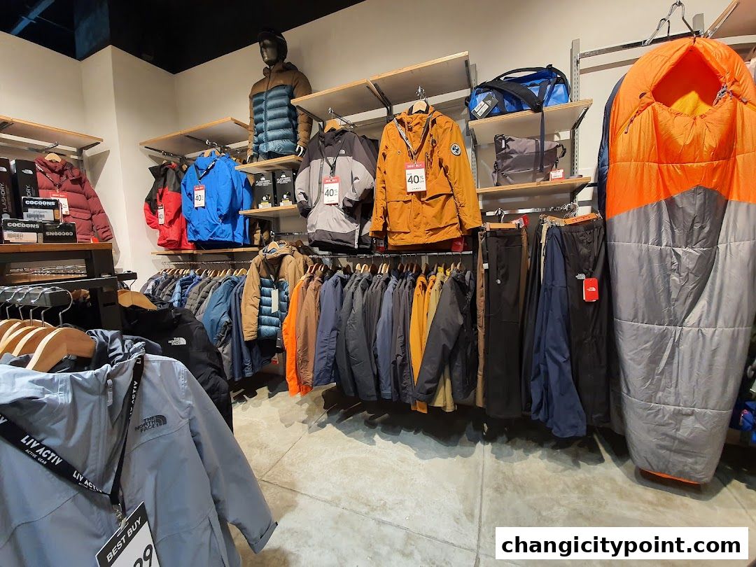 Outdoor apparel and gear displayed on shelves and racks inside a retail store.