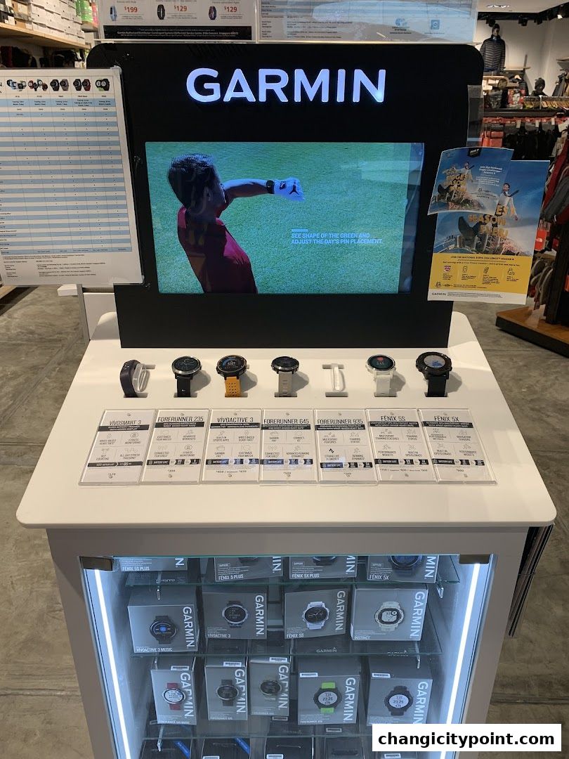 Garmin smartwatches displayed on a stand with product information and boxes below.