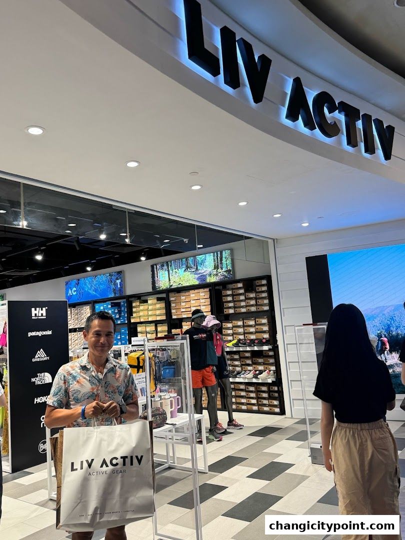 Man holding a shopping bag in front of the Liv Activ store entrance.