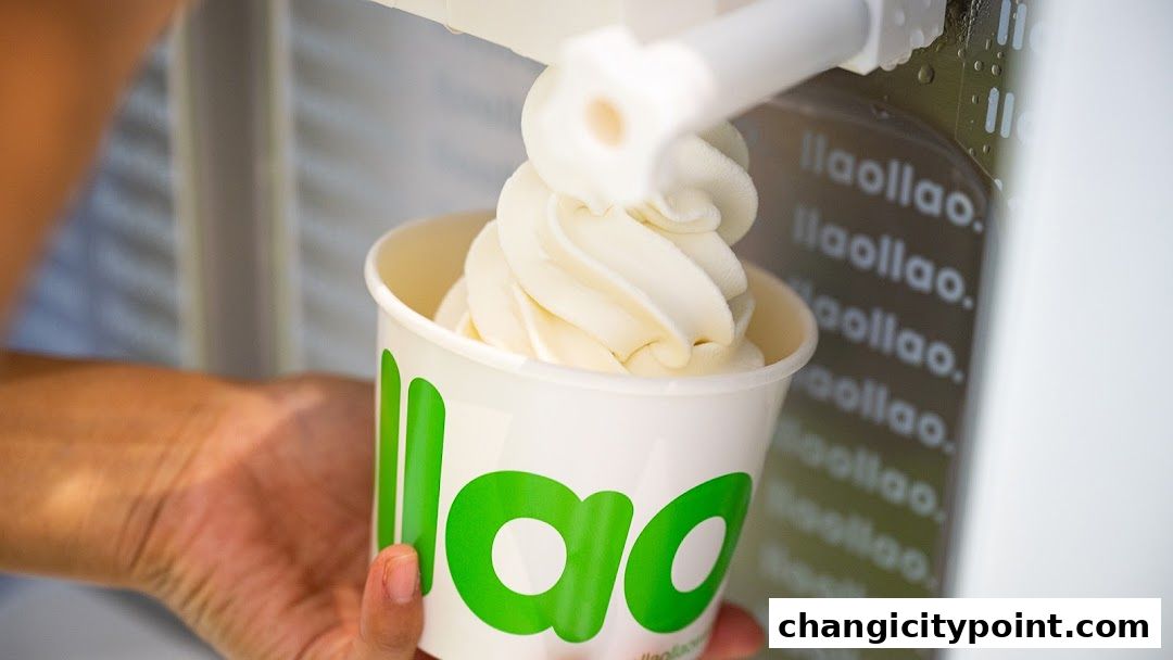 A hand holds a cup of llaollao frozen yogurt being dispensed from a machine.