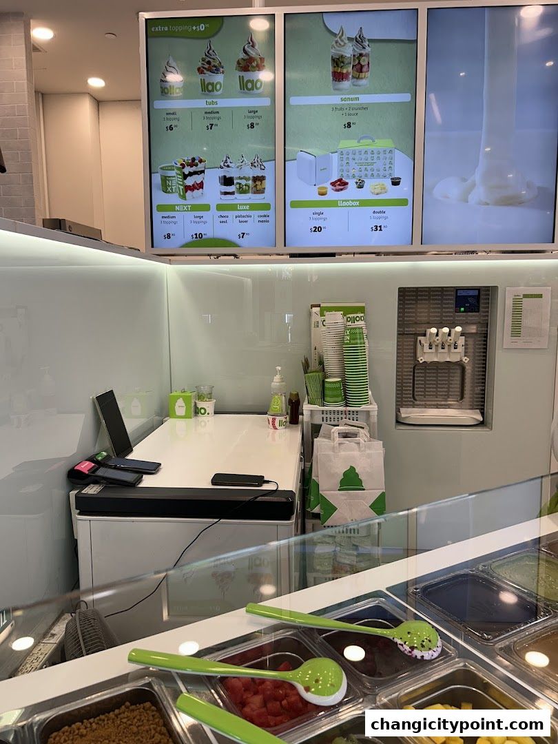 A menu board displaying various frozen yogurt options and toppings at llaollao.