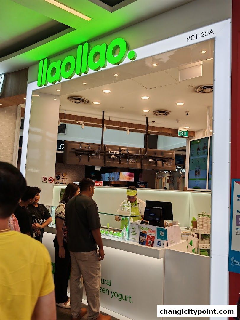 A llaollao frozen yogurt shop with customers queuing and a staff member serving.