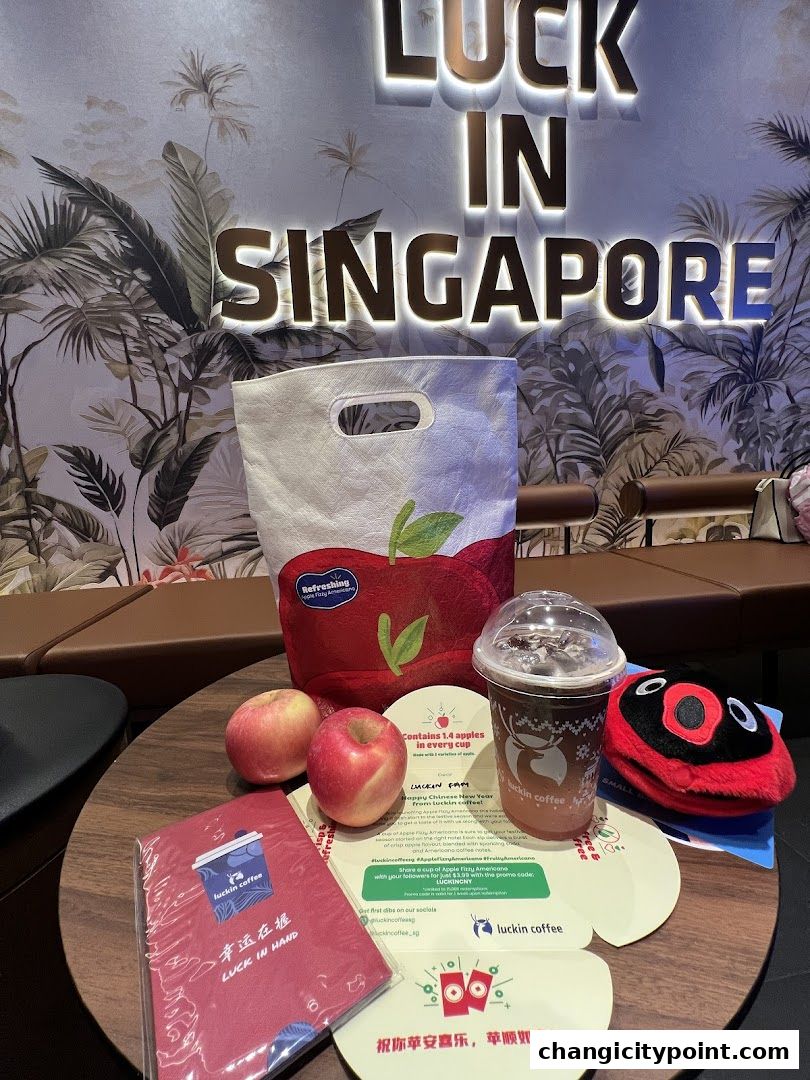 Luckin Coffee merchandise, apples, and a drink are displayed on a table.