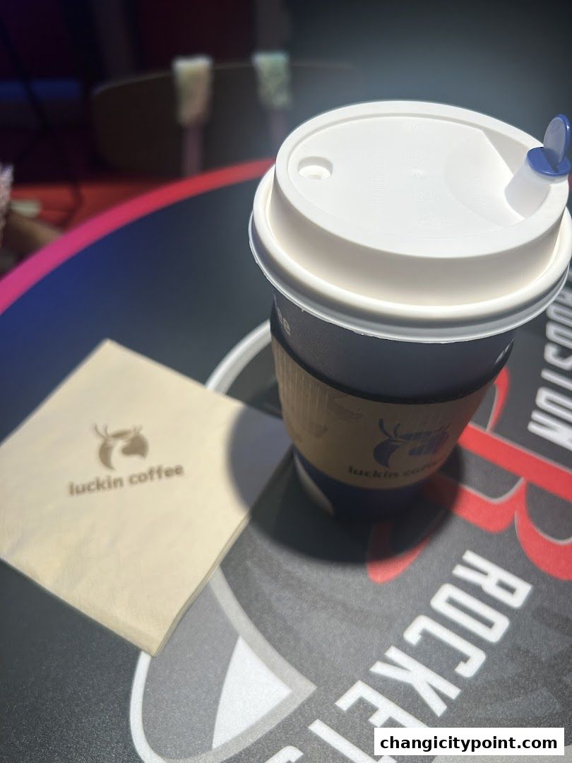 A cup of Luckin Coffee with a napkin on a table.