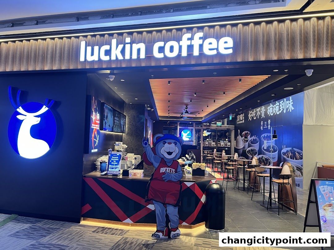 The exterior of a Luckin Coffee shop with a mascot and seating area visible.