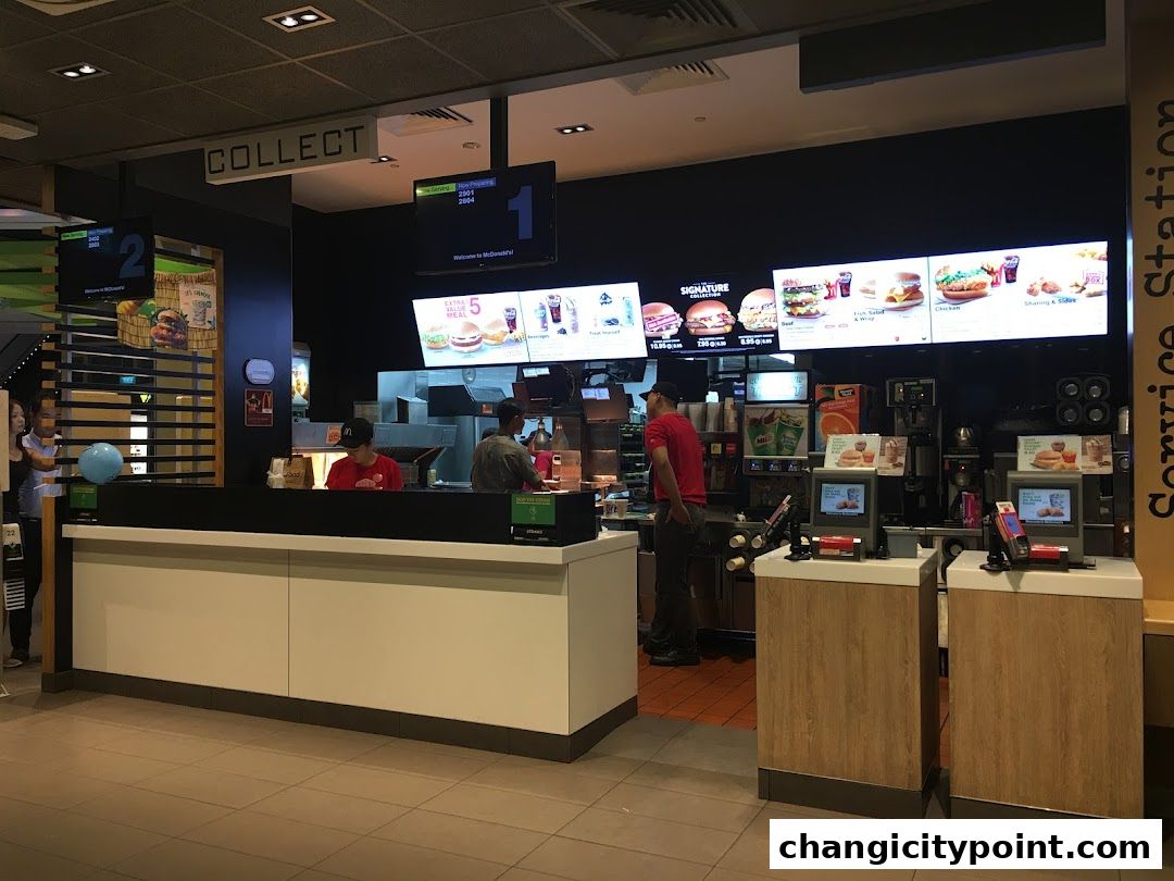 McDonald's counter with digital menus displaying food items and service stations.