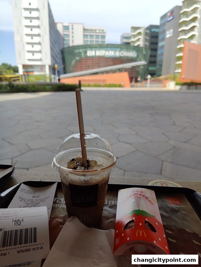 A McCafe drink and a strawberry pie on a tray with receipts.