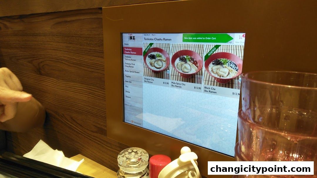 A digital menu displays various ramen options with prices and images.