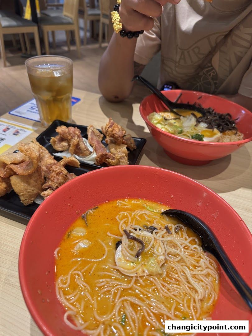 Two bowls of ramen and fried chicken served with iced tea at Menzo Butao.