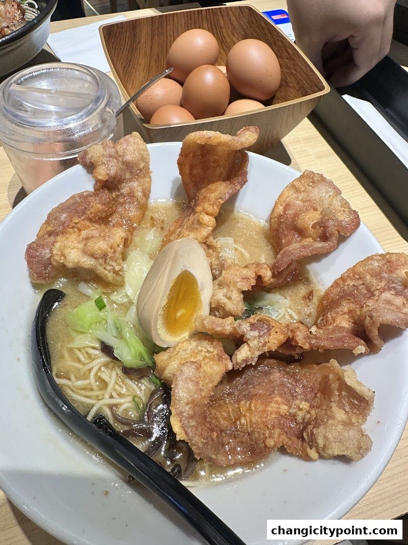 A bowl of ramen with crispy fried chicken, egg, and vegetables.