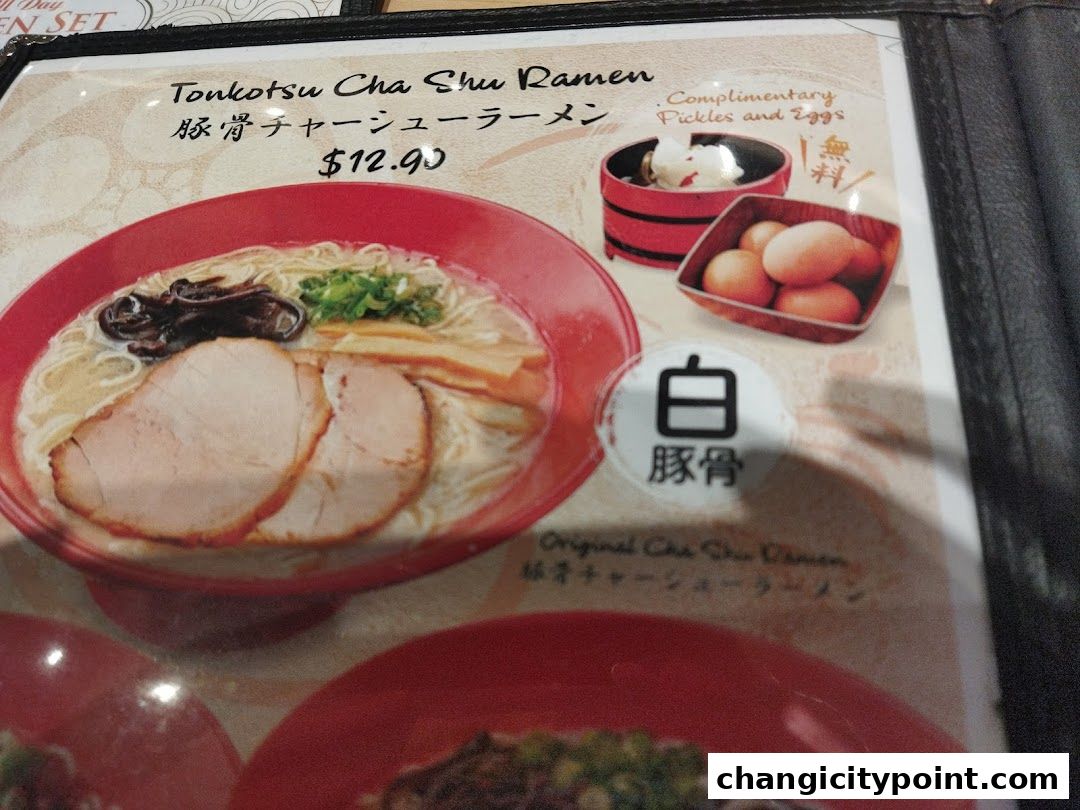 A menu item featuring Tonkotsu Cha Shu Ramen with complimentary pickles and eggs.
