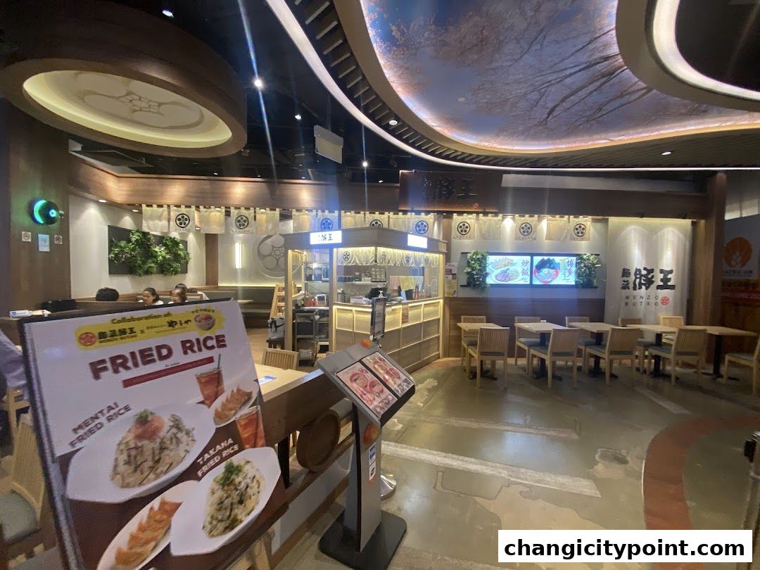 Interior view of Menzo Butao Changi City Point restaurant with seating and a menu board.