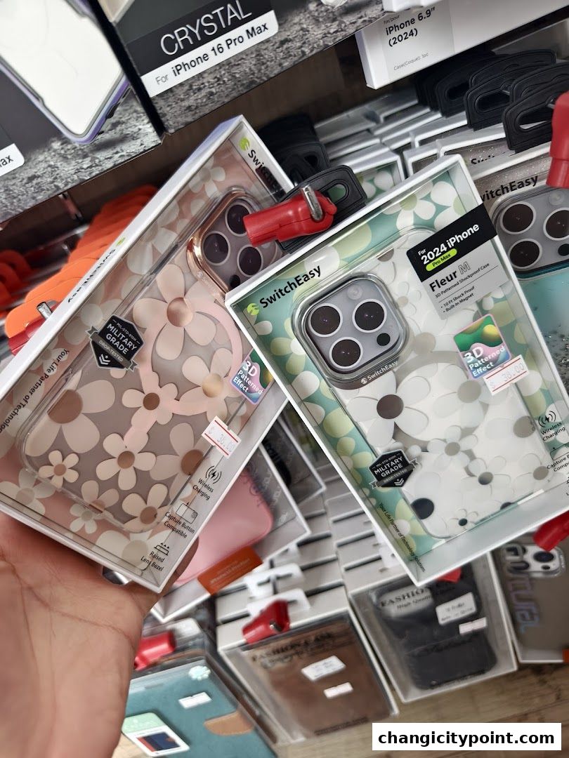 A hand holds up two phone cases with floral patterns for iPhones.