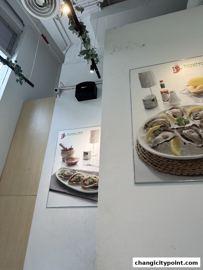 Interior view of a restaurant with posters of grilled oysters and other seafood dishes.