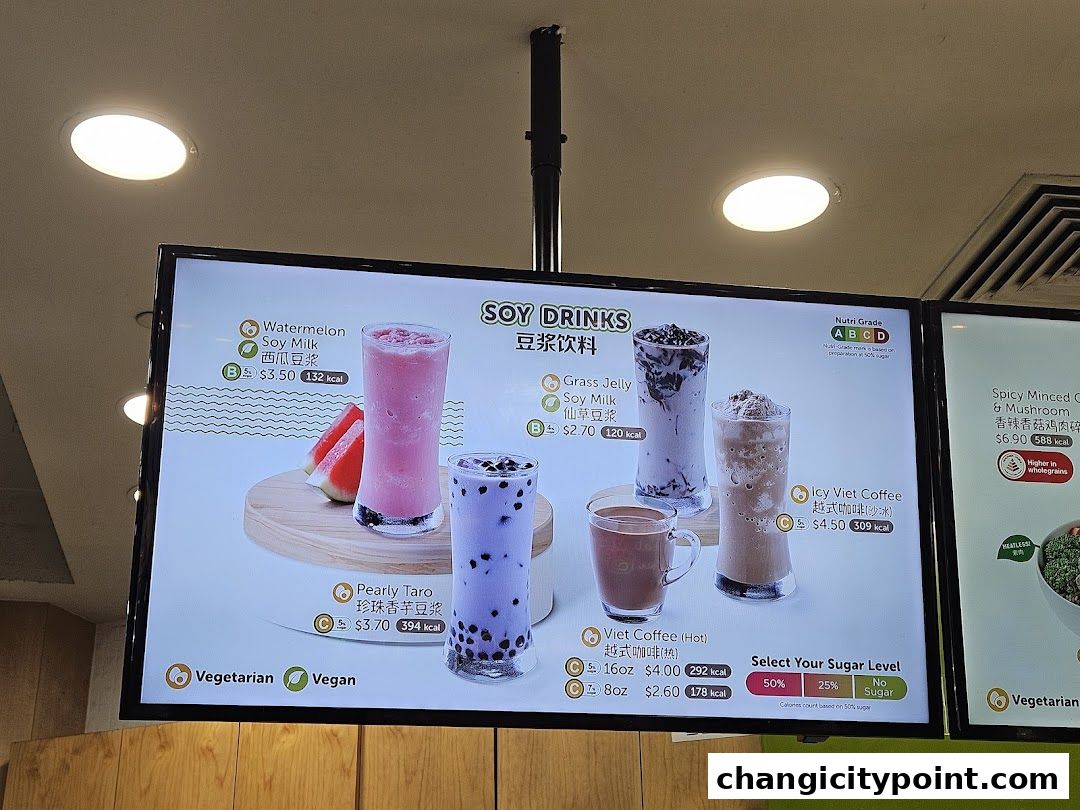 A digital menu board displaying various soy drinks and coffee options with prices and calorie information.