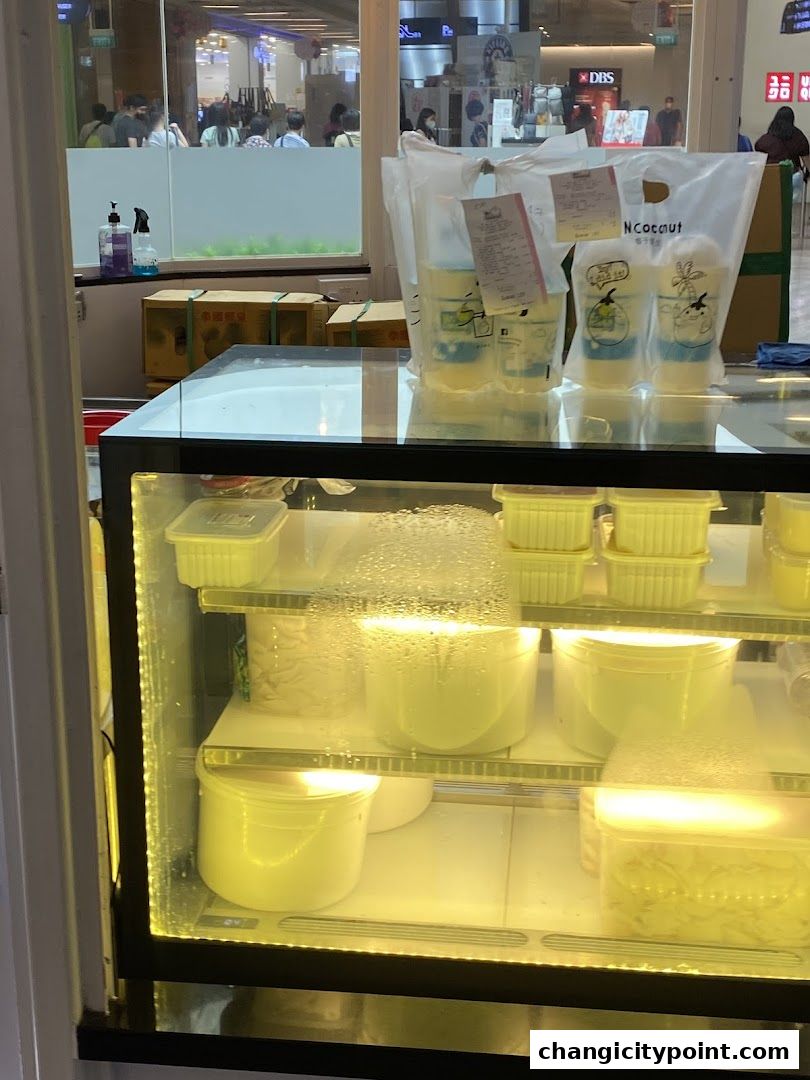 Mr. Coconut shop display with drinks and ingredients in a refrigerated case.