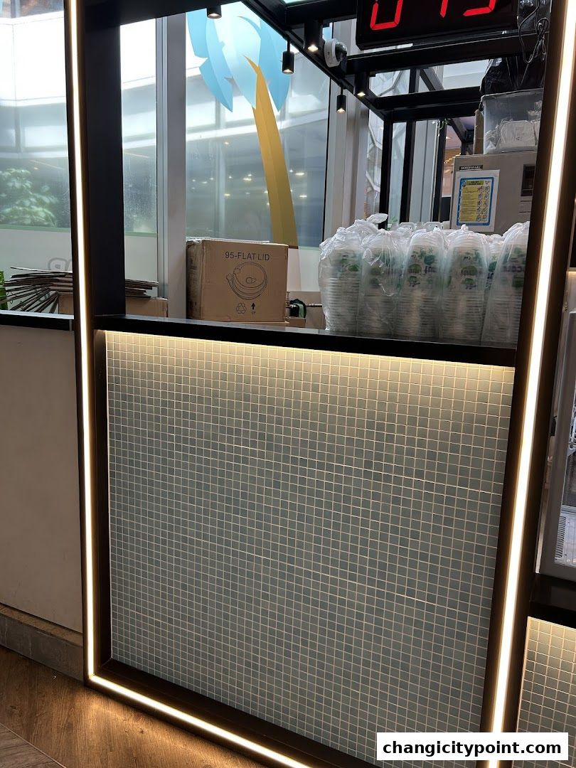 A counter with stacked cups and a box labeled '95-FLAT LID' at Mr. Coconut.