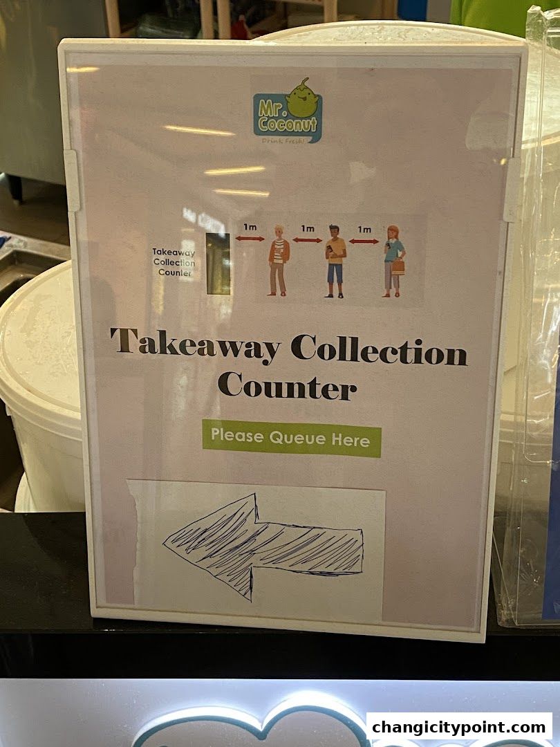 Signage for Mr. Coconut's takeaway collection counter with social distancing guidelines.