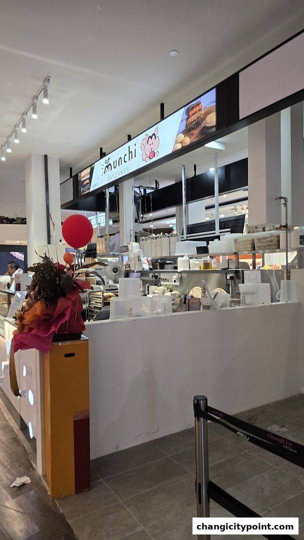 The exterior of Munchi Pancakes shop with its signage and display counter.