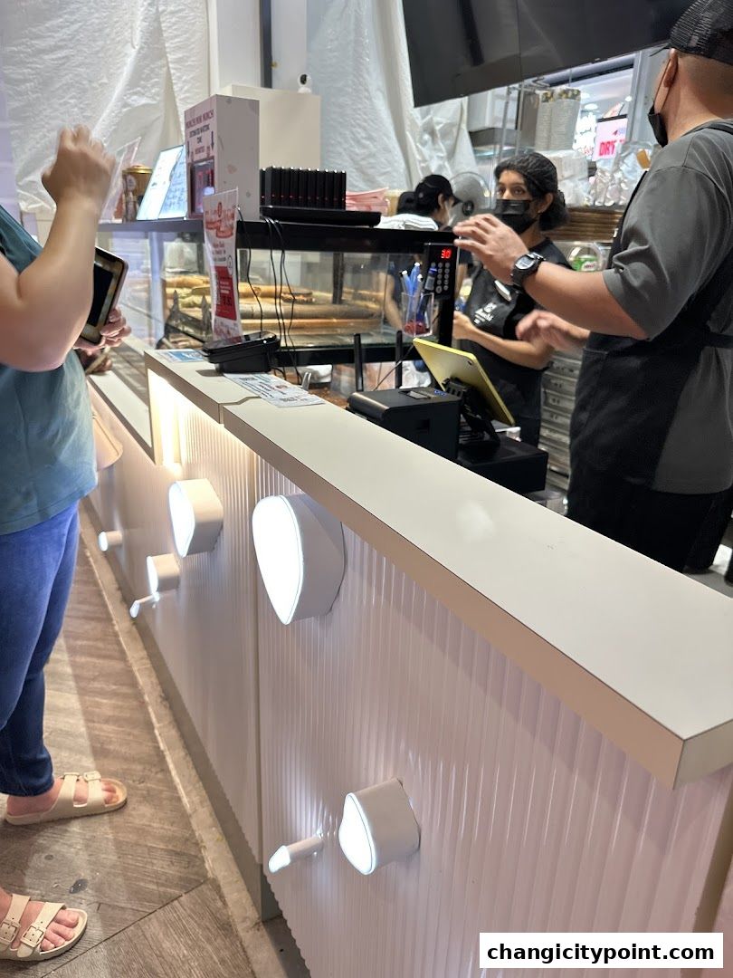 Customers interact with staff at the counter of Munchi Pancakes.
