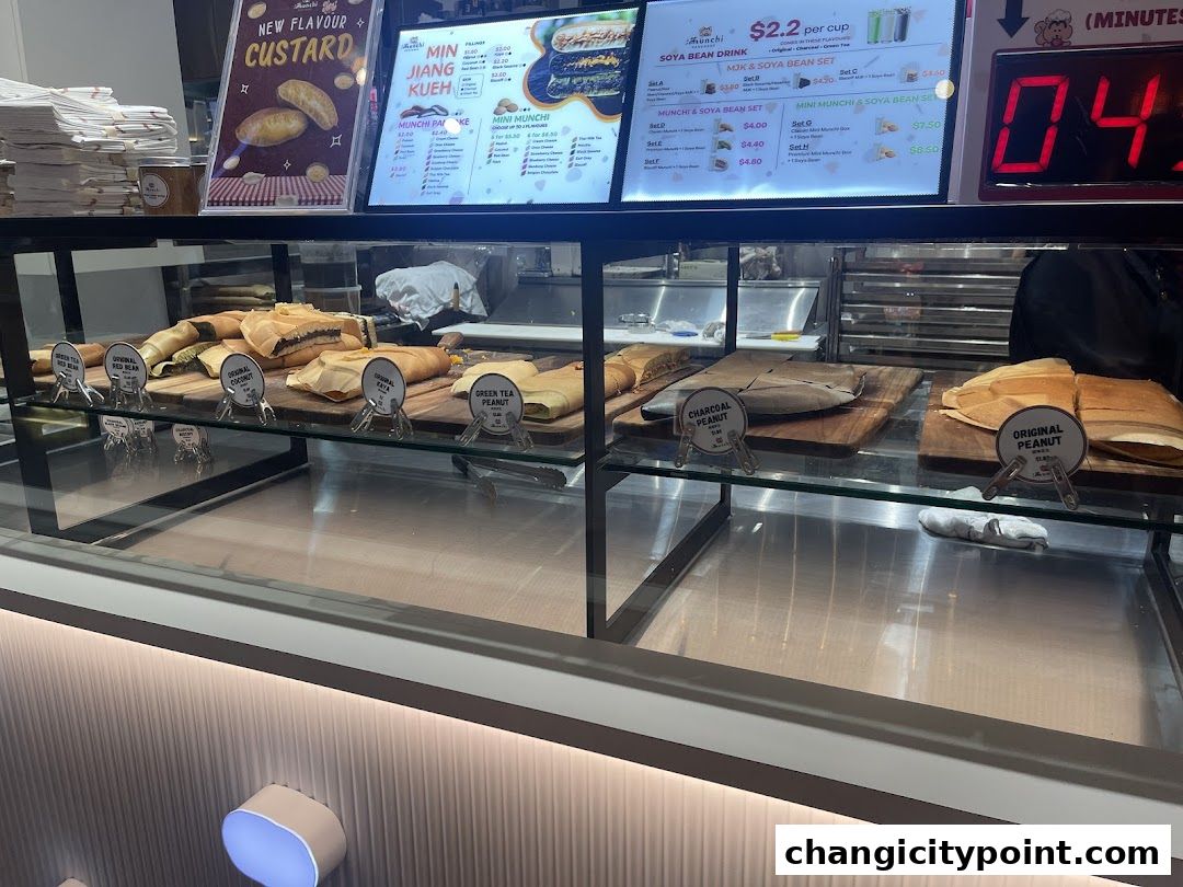 A display case filled with various types of pancakes and a menu board above.