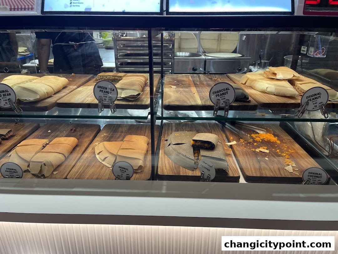 A display case filled with various sweet and savory pancakes with different fillings.