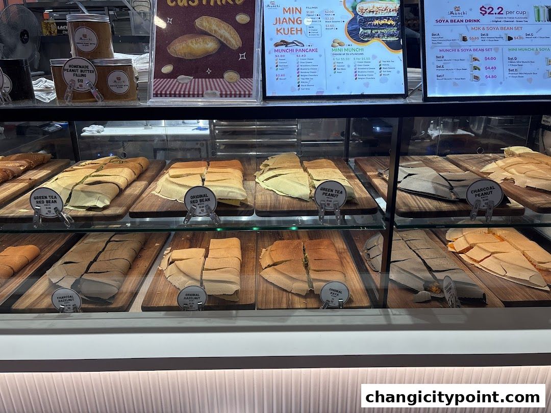 A display case filled with various flavors of Munchi pancakes and jars of peanut butter.