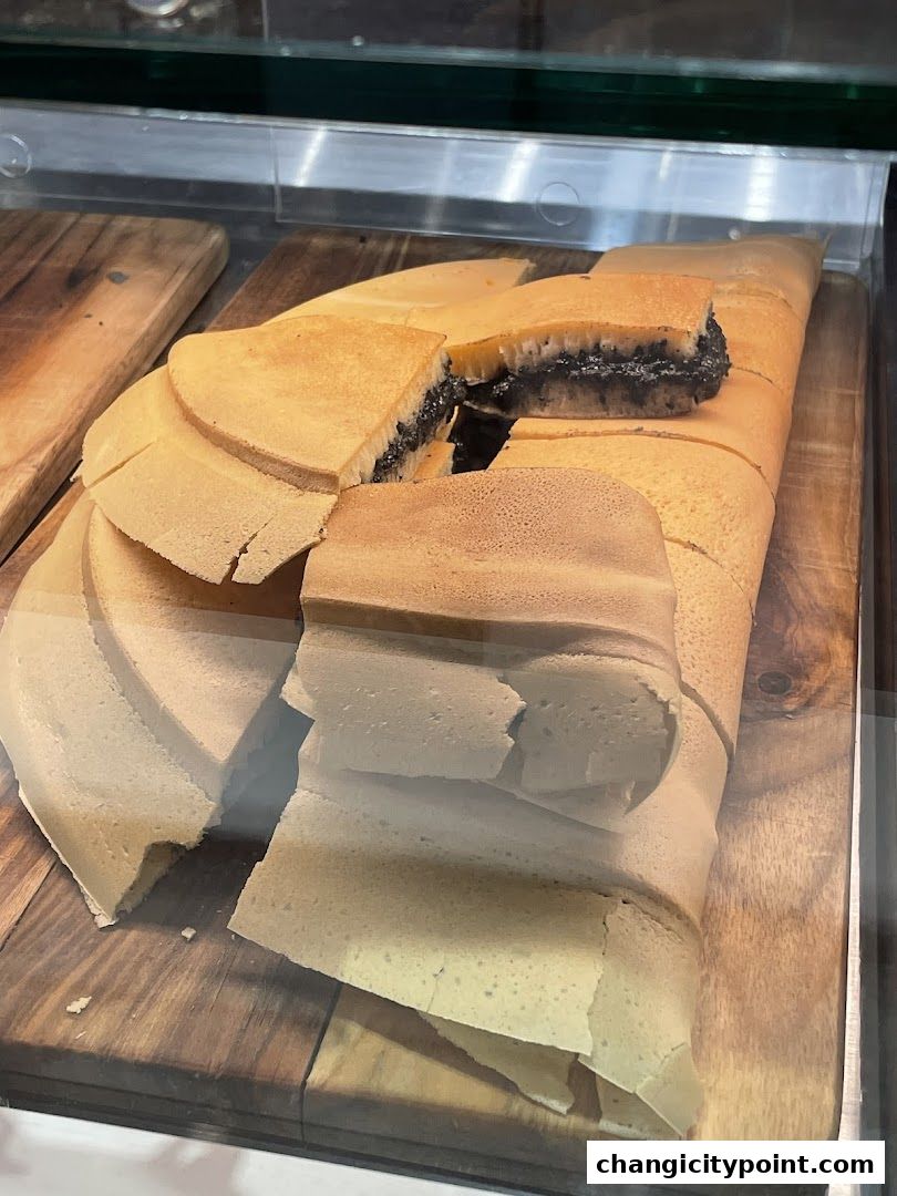 A close-up of freshly made pancakes with a dark filling, sliced and arranged on a wooden board.