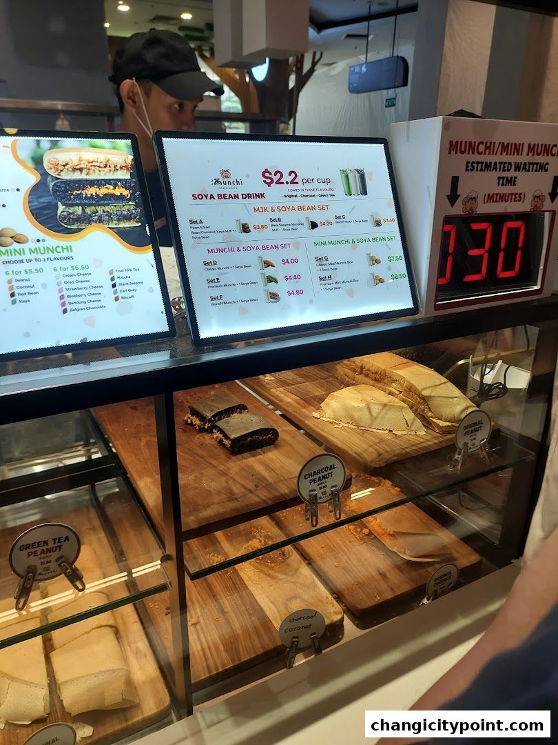 A display case and digital menus for Munchi Pancakes, showing pancake flavors and drink sets.
