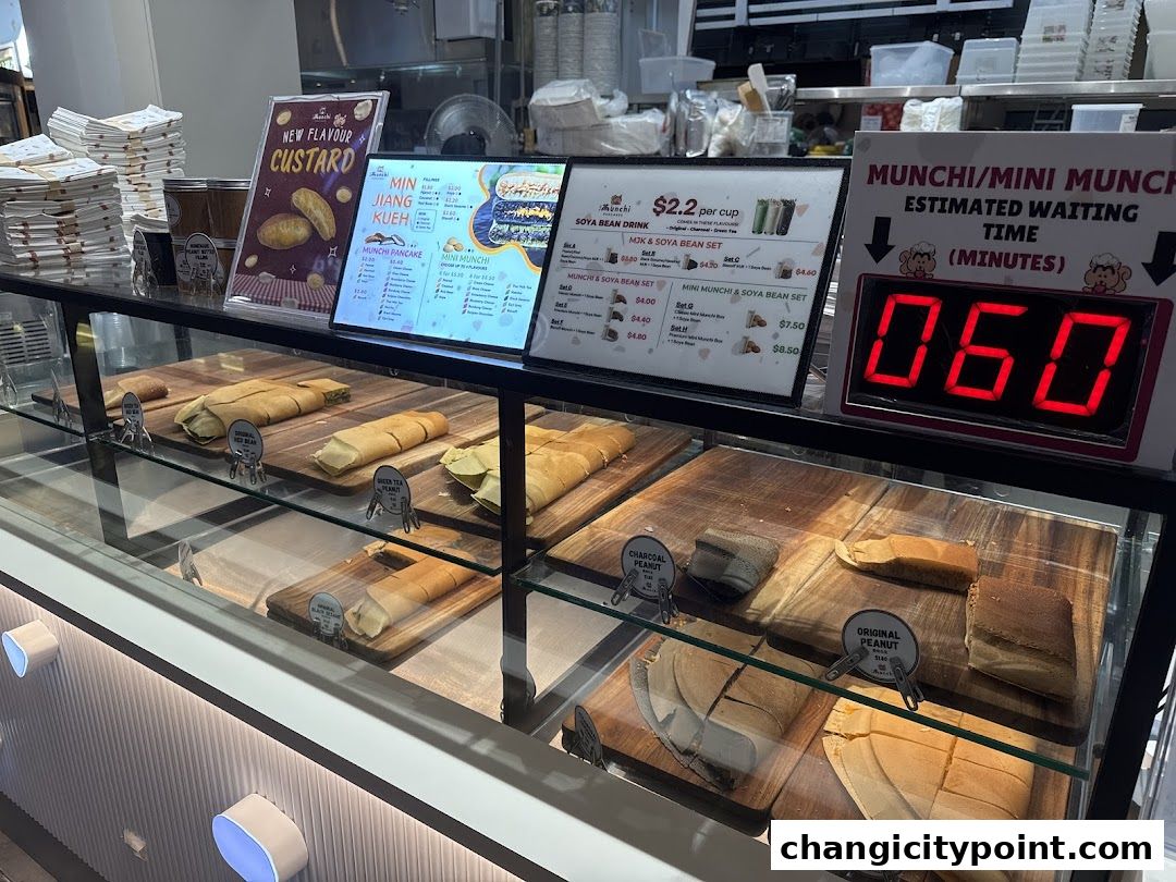 A display case filled with various types of pancakes and a digital waiting time indicator.