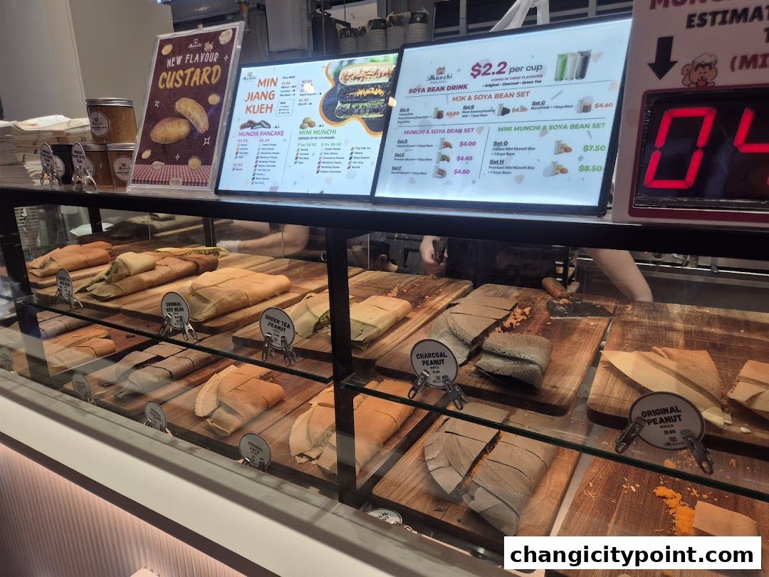 A display case filled with various types of pancakes and a menu board above.