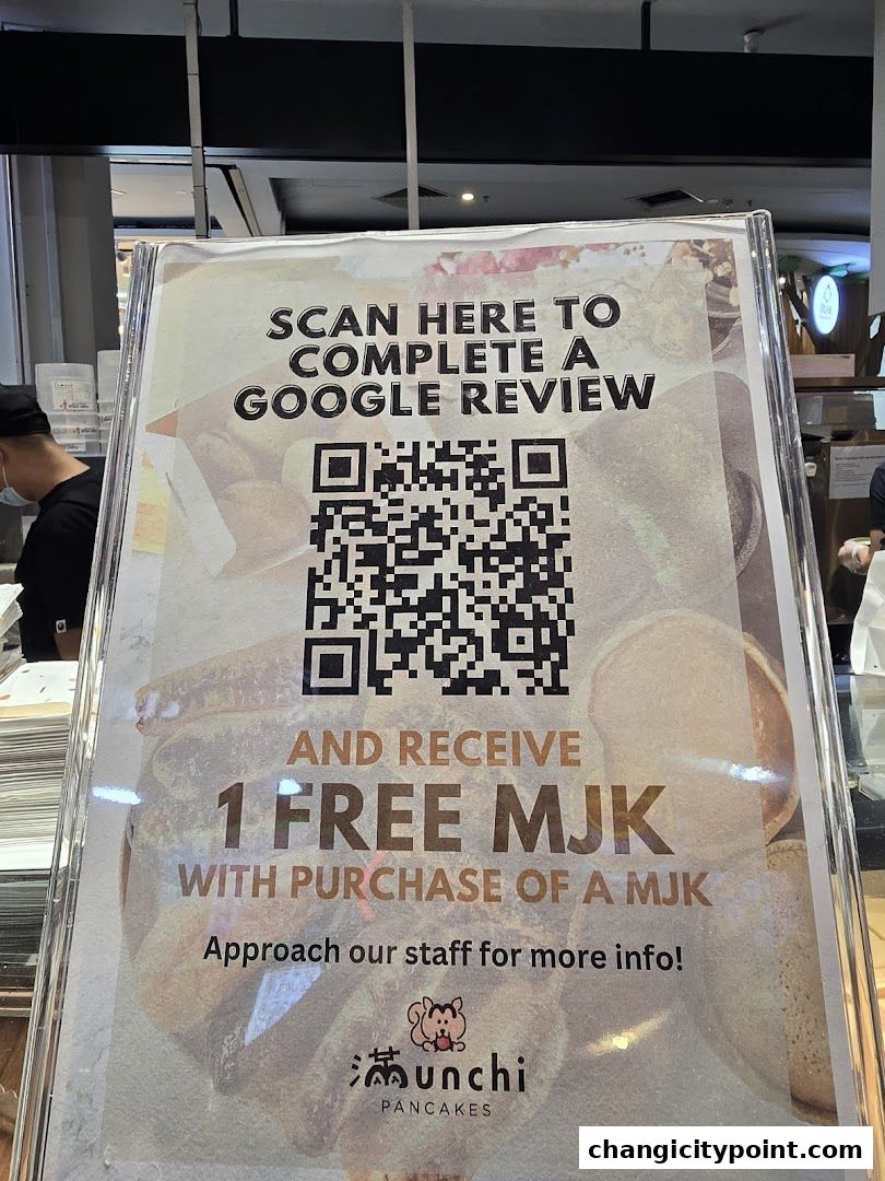 A sign at Munchi Pancakes offers a free item with a Google review.