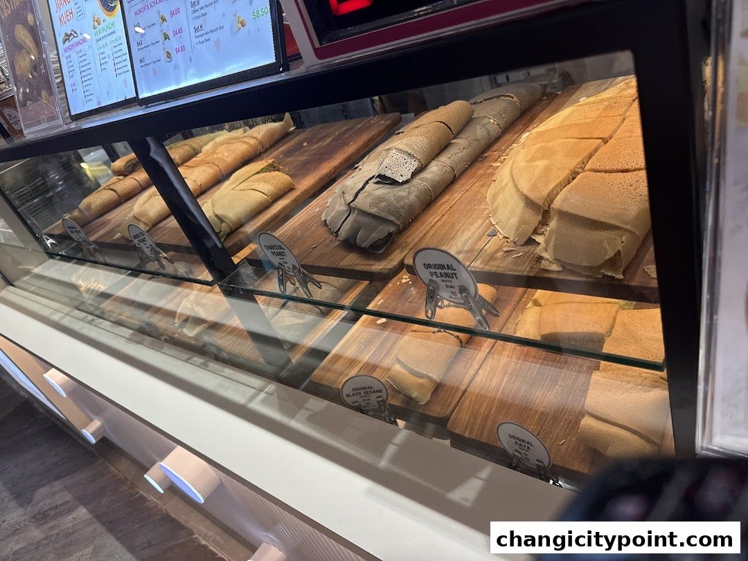 A display case filled with various types of freshly made pancakes and crepes.