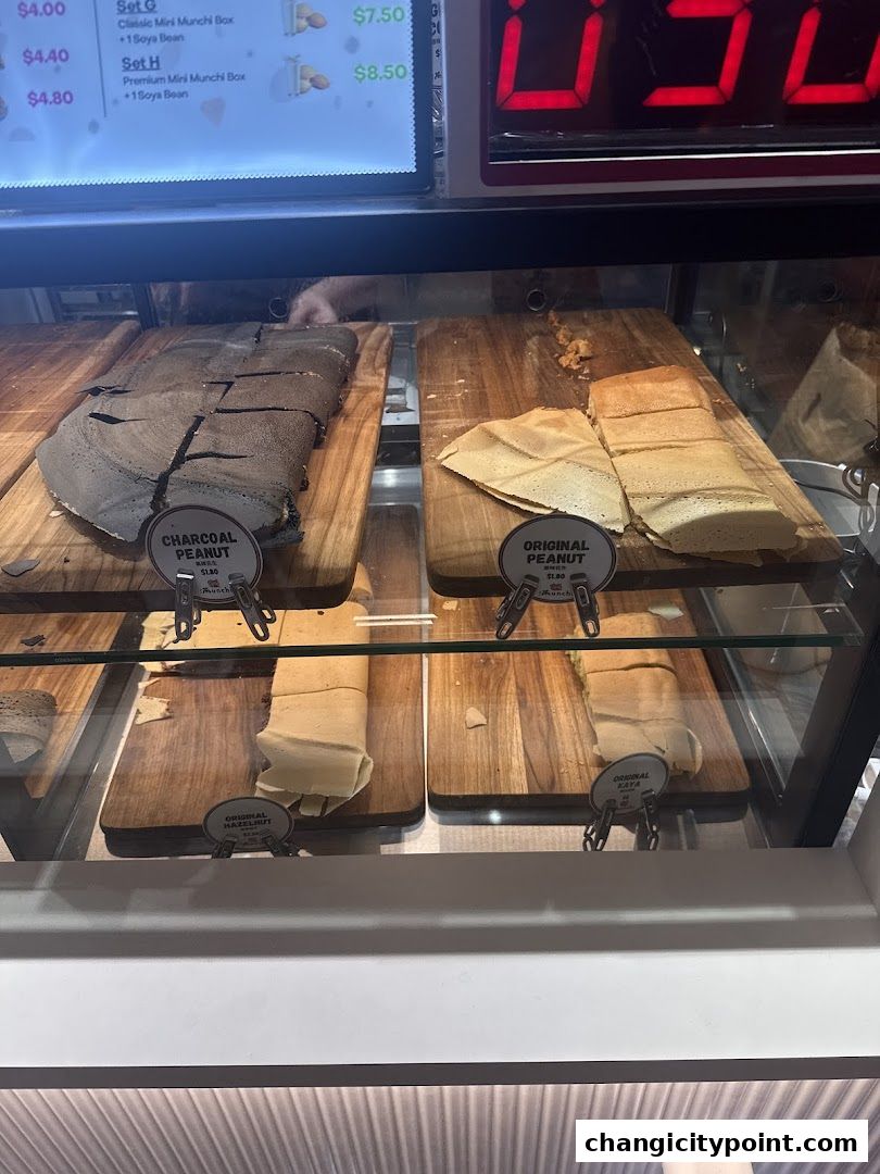 Display case showing various flavors of Munchi Pancakes, including charcoal peanut and original peanut.