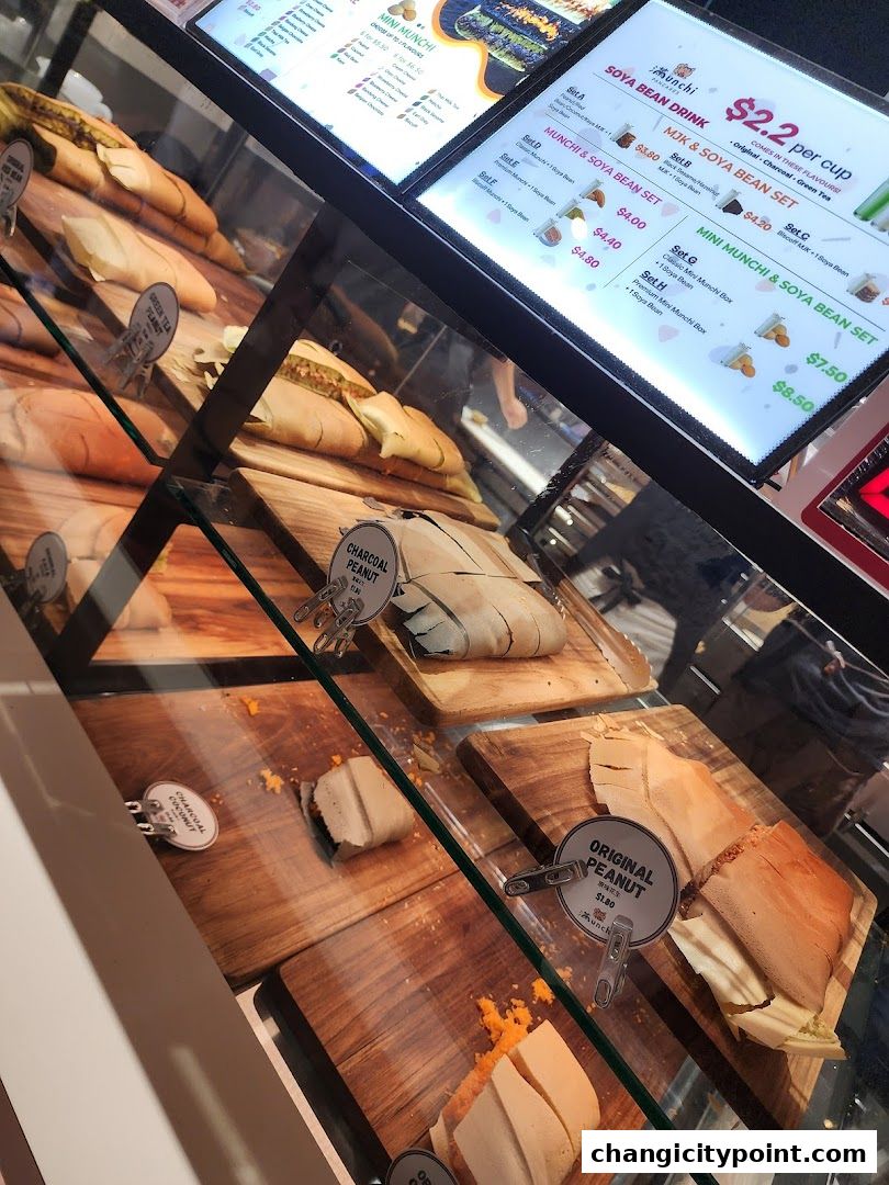 A display case filled with various types of pancakes and a menu board above.