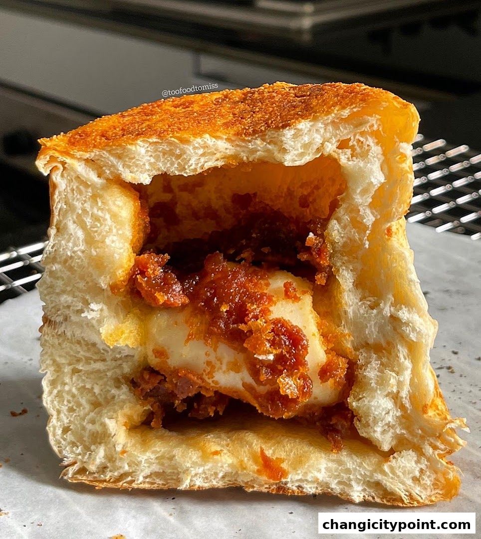 A close-up of a hollowed-out bread roll filled with a savory mixture.