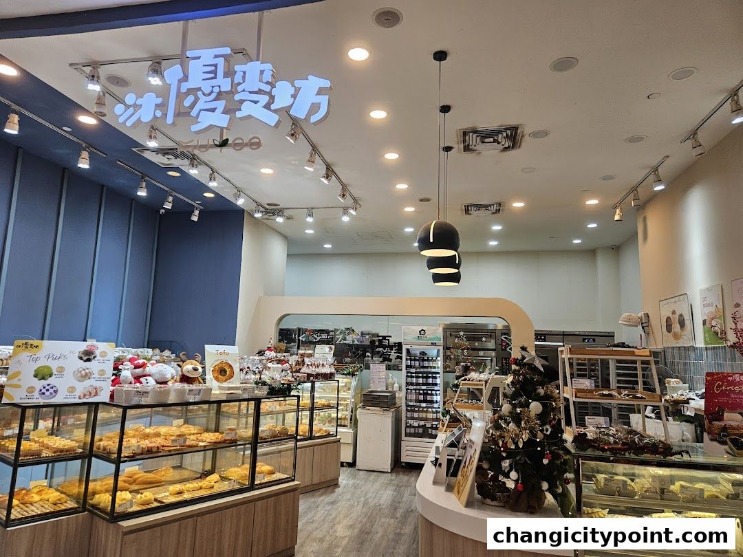 Interior view of Muyoo Bakery with display cases full of pastries and a Christmas tree.