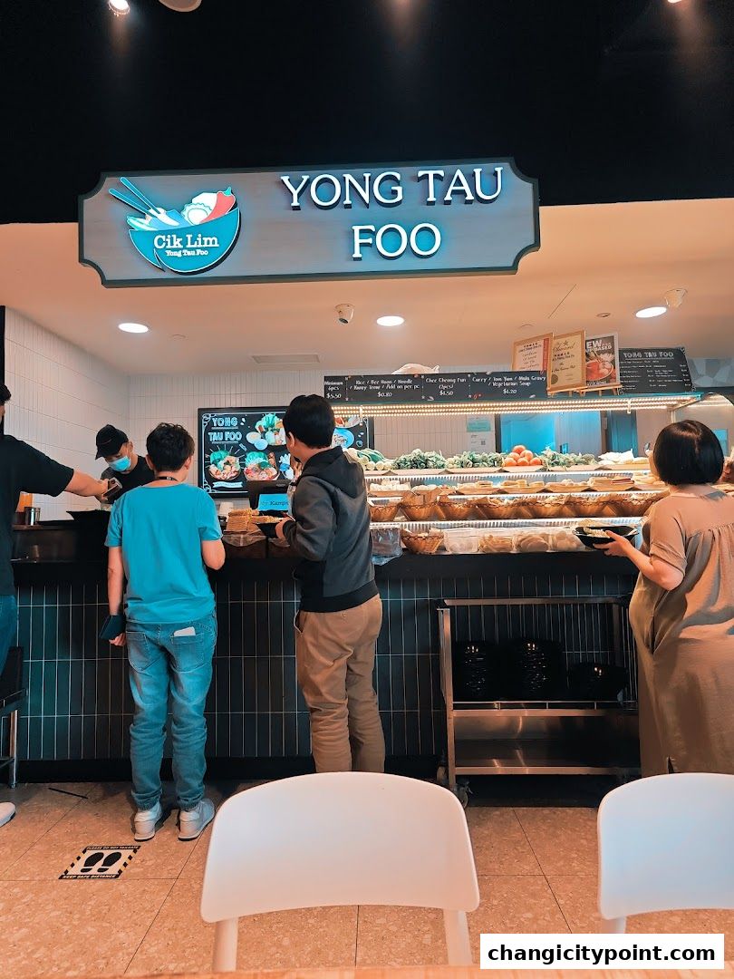 Customers ordering Yong Tau Foo at a food stall with a display of ingredients.