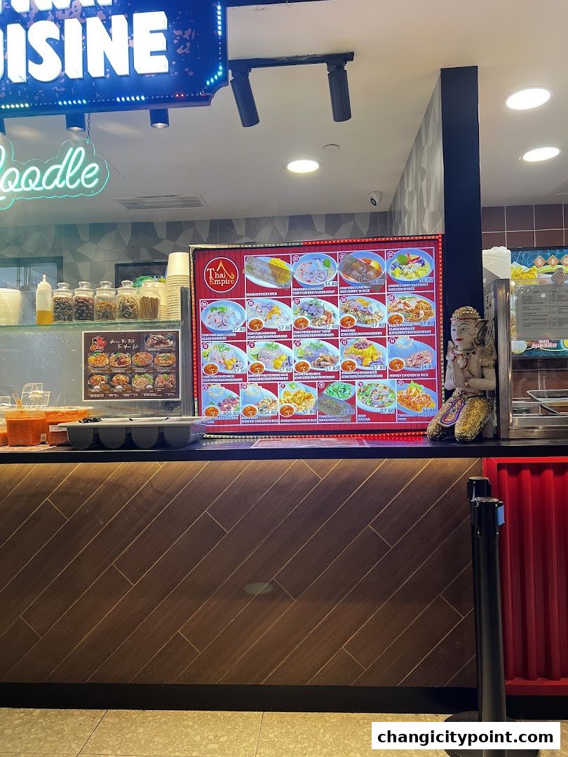 A digital menu board displays various Thai dishes with prices and images.