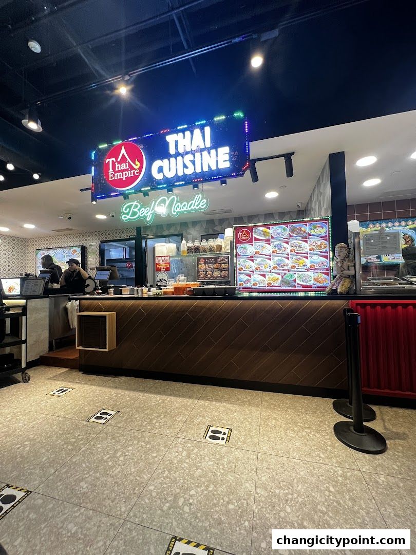 A Thai cuisine restaurant counter with a menu board and staff behind it.