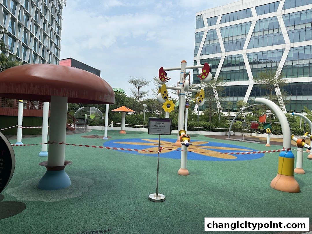 A closed playground with colorful mushroom and butterfly-themed structures, cordoned off with tape.