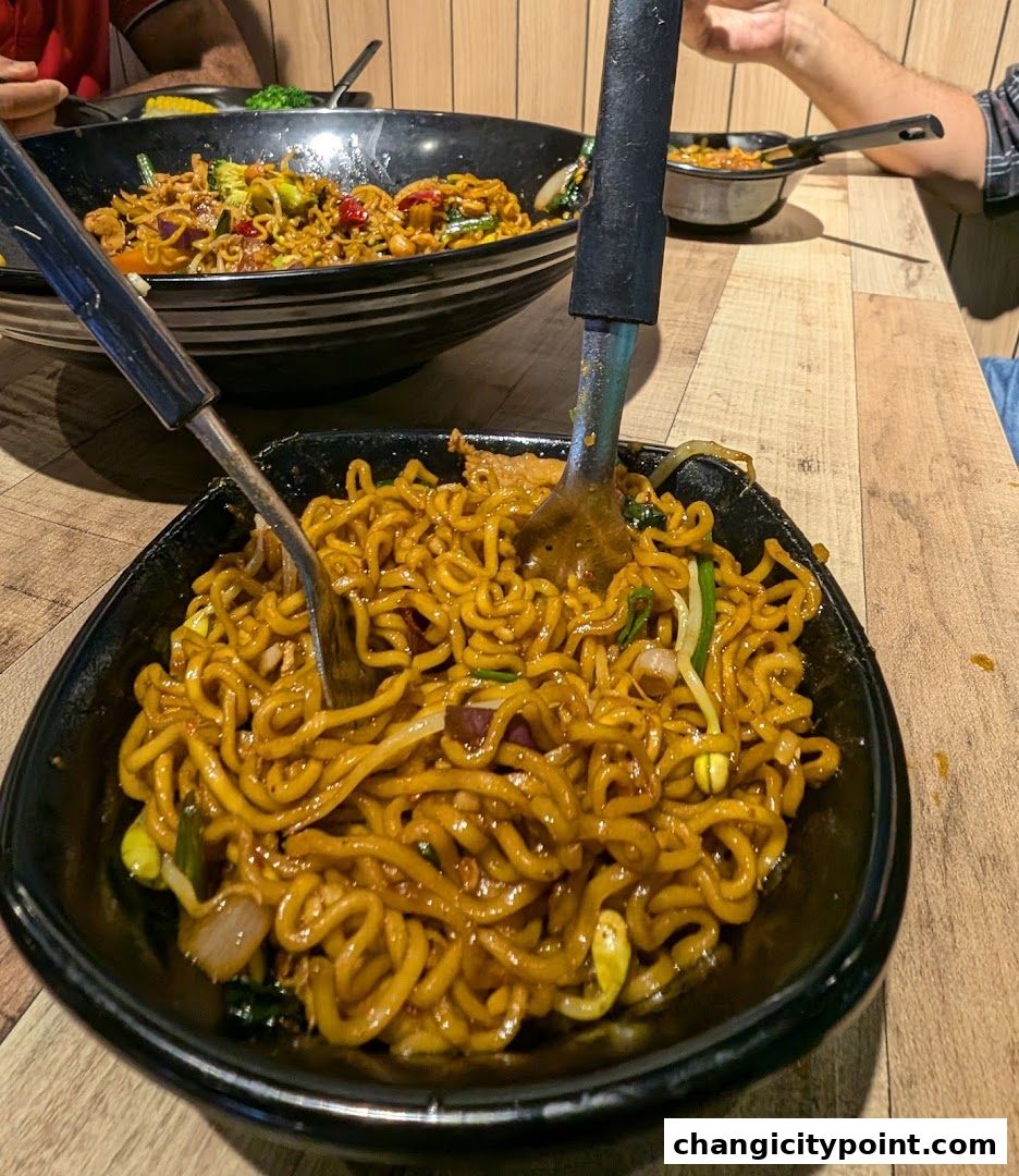 Close-up of a delicious bowl of noodles being served with tongs and a fork.