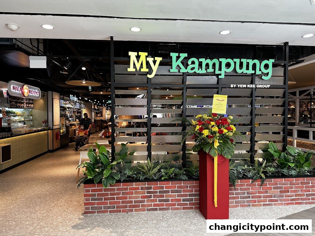 The entrance of 'My Kampung' restaurant, featuring its prominent signage and floral decorations.