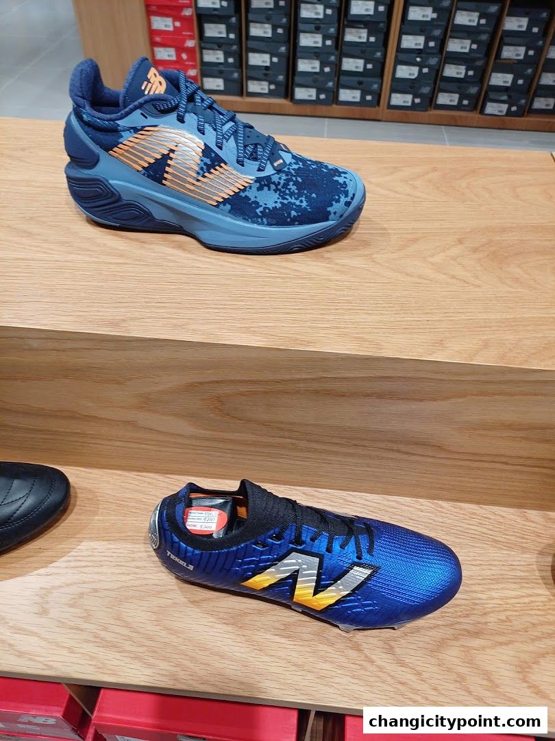 New Balance shoes displayed on wooden shelves in a retail store.