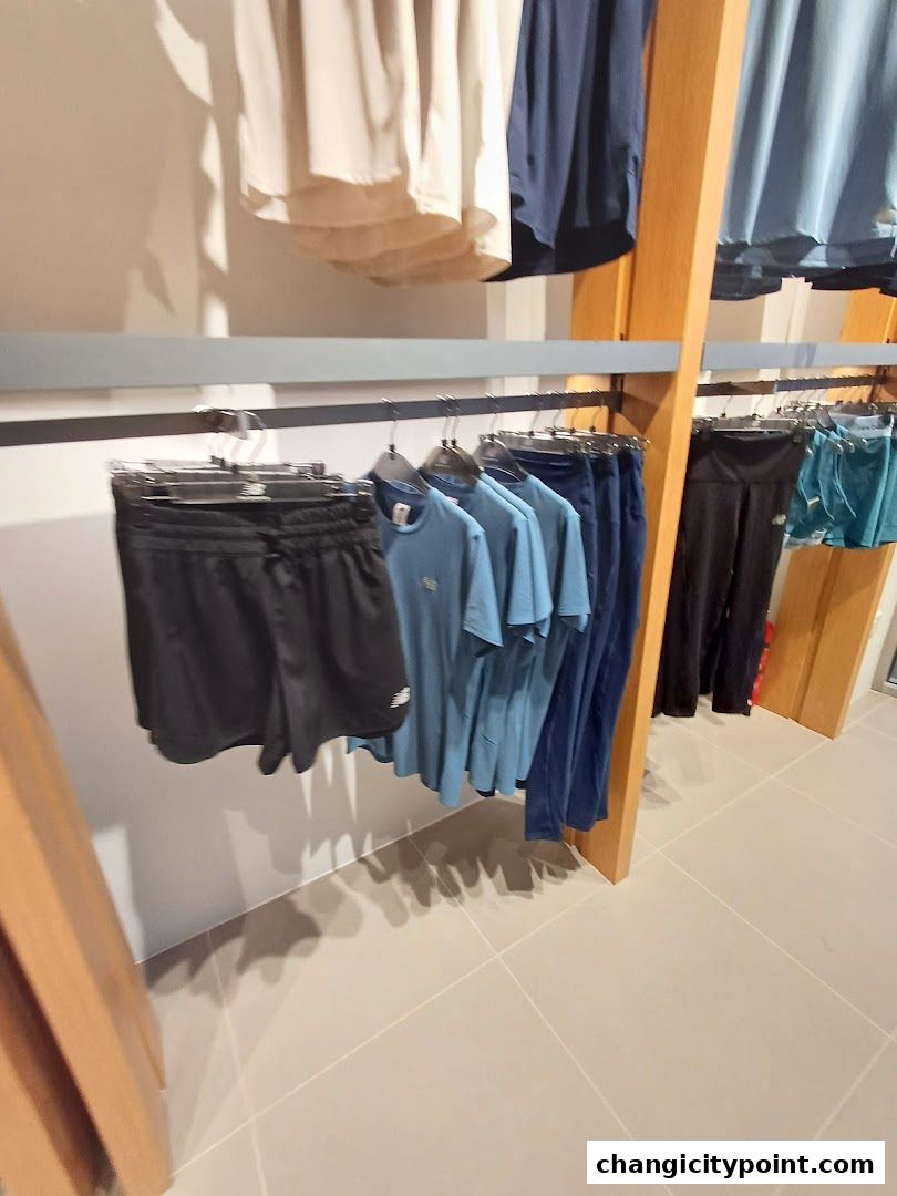 New Balance store interior displaying athletic apparel on racks.