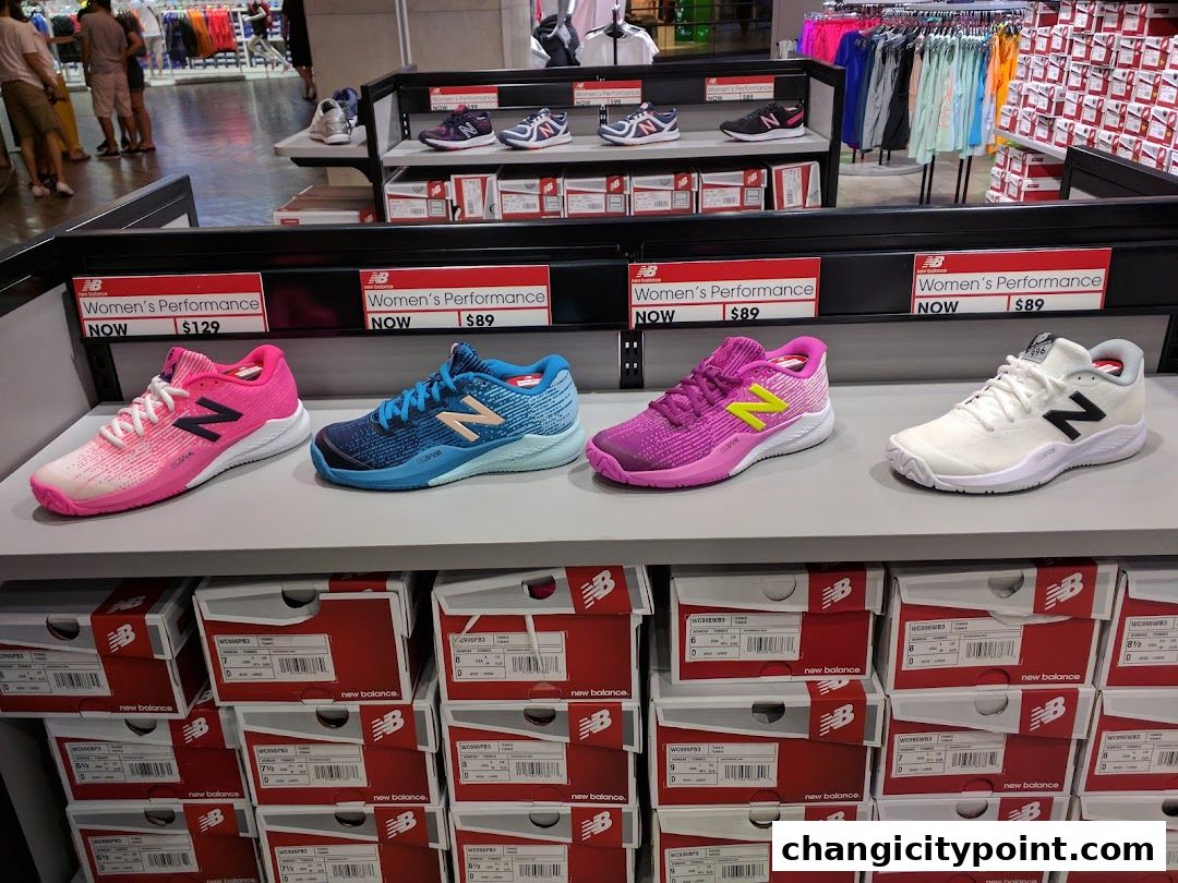 New Balance store display featuring colorful women's performance shoes and stacked shoe boxes.