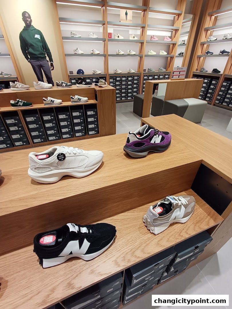 Interior view of a New Balance store showcasing various sneakers on display shelves.