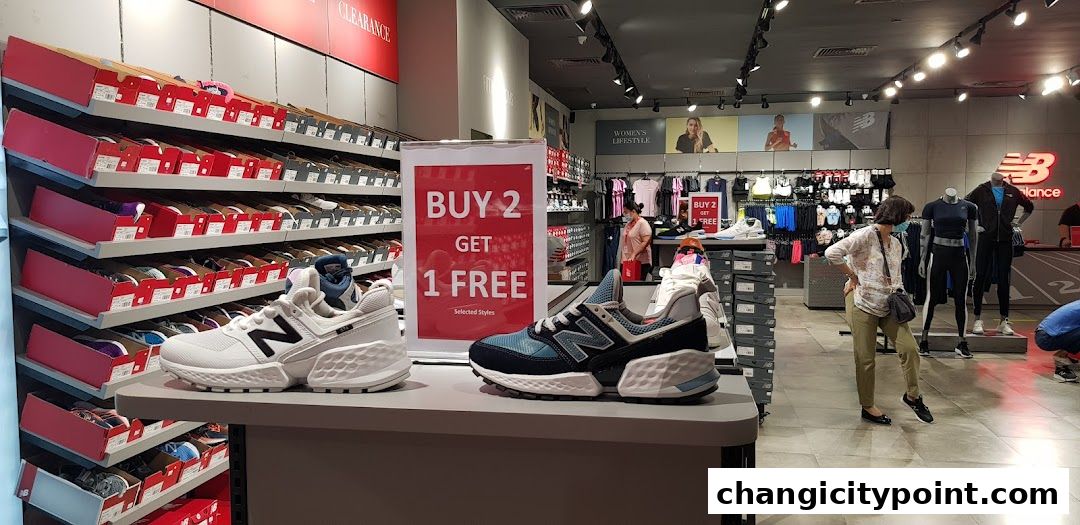 Interior of a New Balance store showcasing shoes, apparel, and a 'Buy 2 Get 1 Free' promotion.