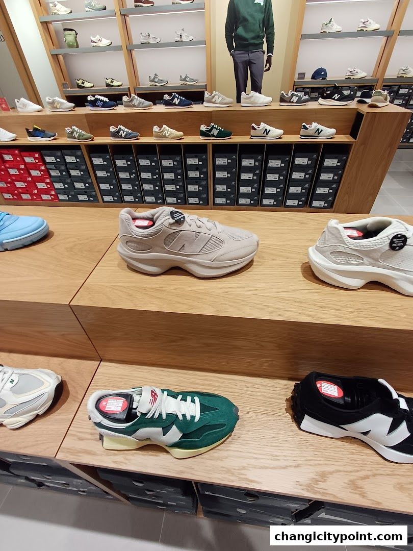New Balance shop interior displaying various sneaker models on shelves and display stands.