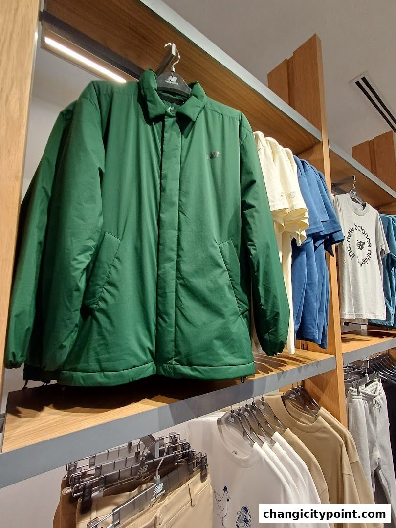 New Balance store interior showcasing a green jacket and various apparel on display.